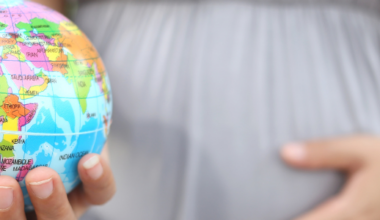 Foto del embarazo de mujer con una bola del mundo en la mano