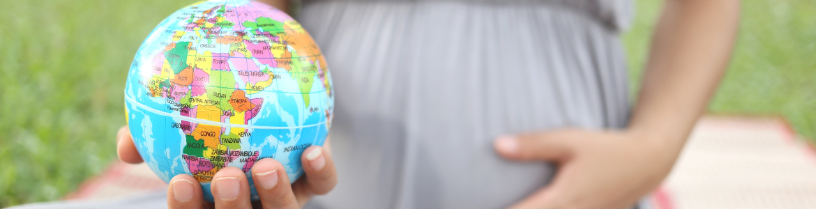 Foto del embarazo de mujer con una bola del mundo en la mano