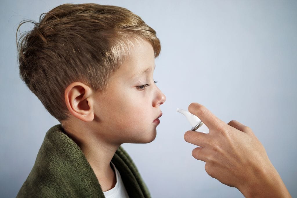 Niño resfriado con aplicador de suero