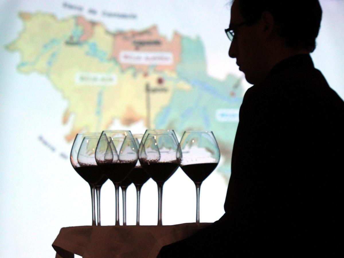 Un camarero lleva copas de vino para una cata de vinos.