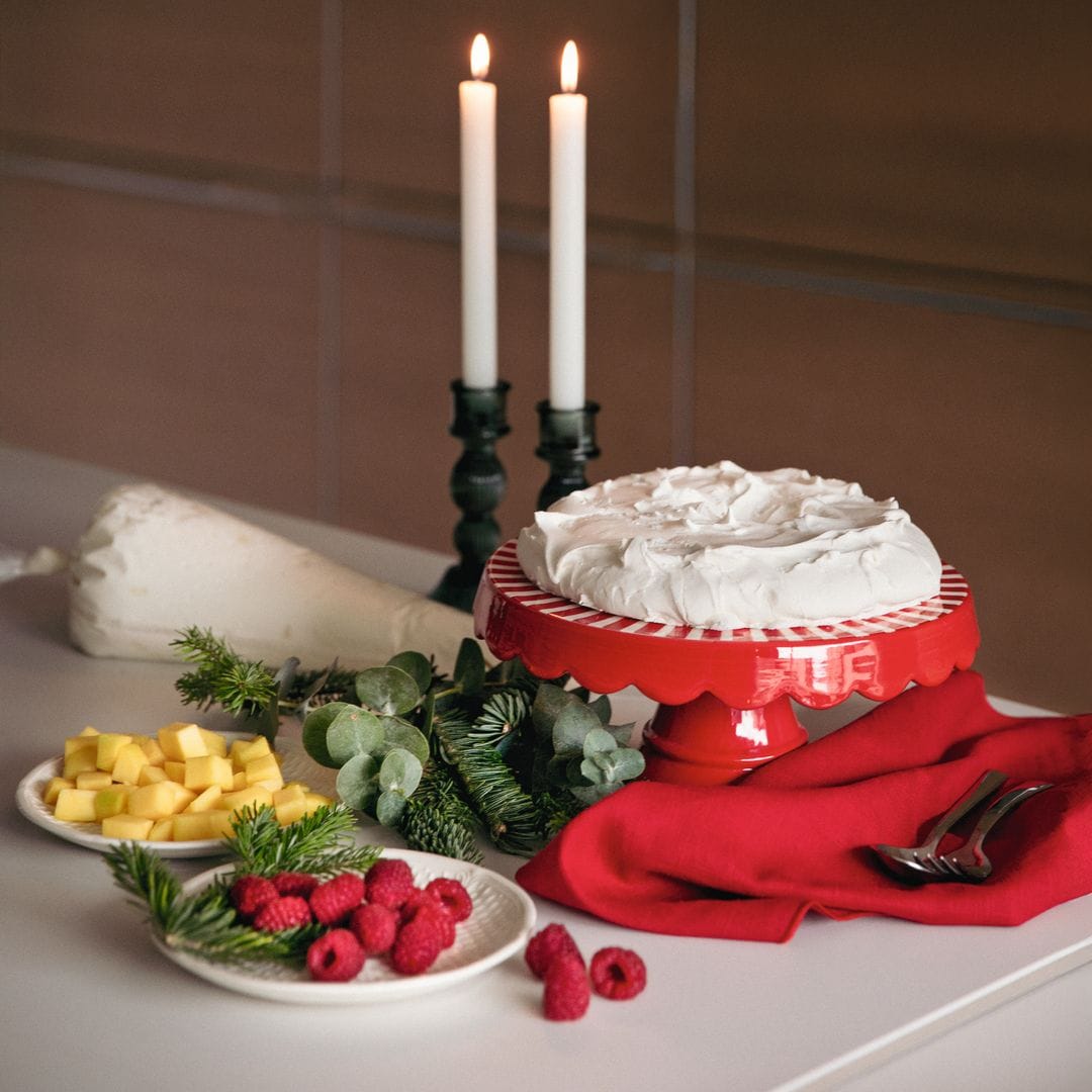 Tarta con crema, frutas y velas en una mesa decorada para una ocasión especial.