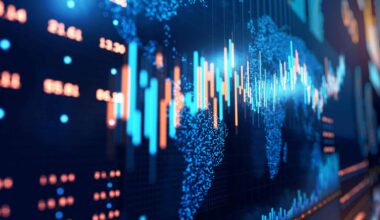 En primer plano, un gráfico bursátil destaca sobre el fondo azul oscuro. Detrás del gráfico, desenfocados, a la izquierda, hay un panel de operaciones bursátiles, y, a la derecha, un mapa mundial.