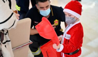 Niño disfrazado de Papá Noel con un casco de bombero
