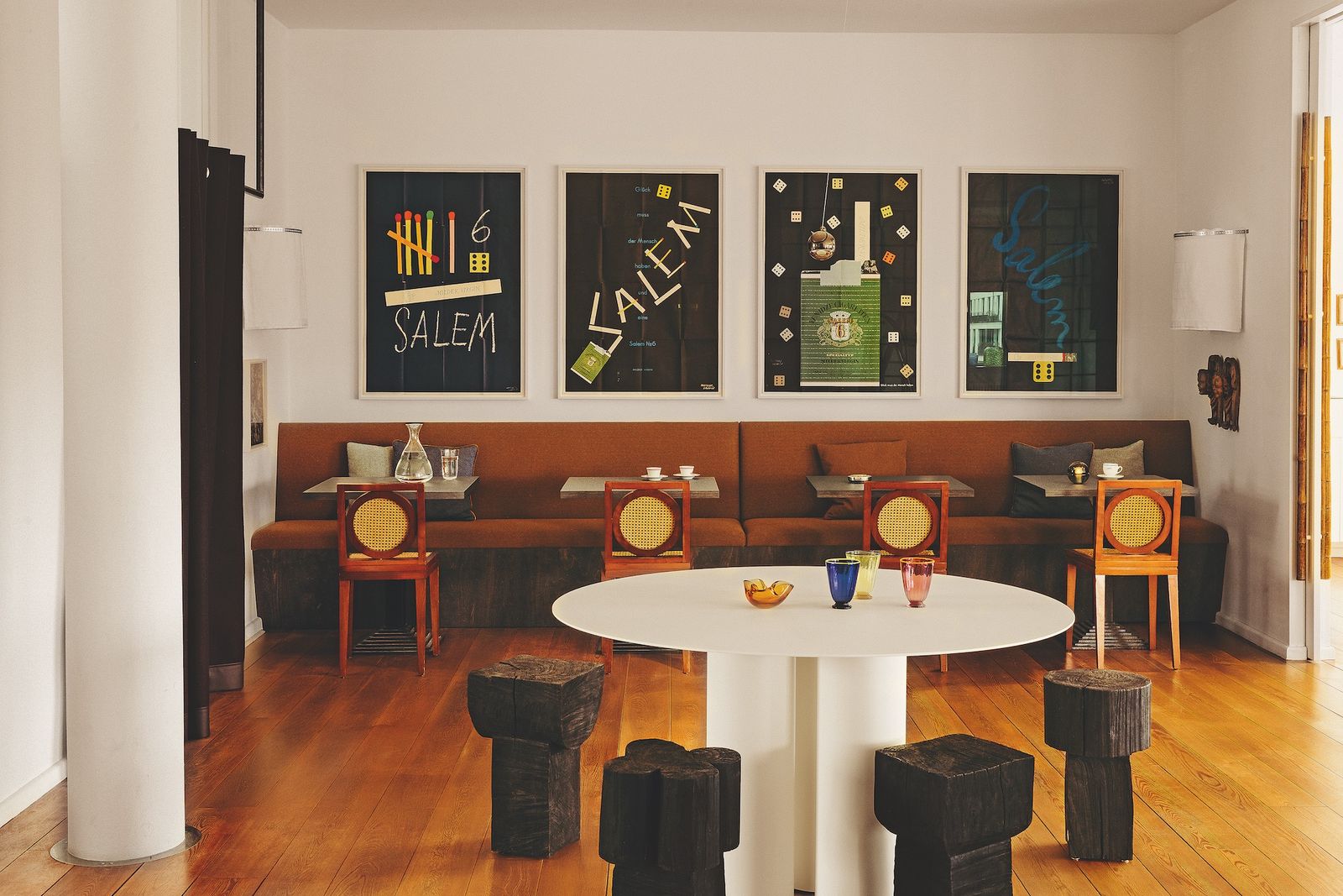 Comedor con mesa blanca redonda y una serie de cuatro cuadros en la pared