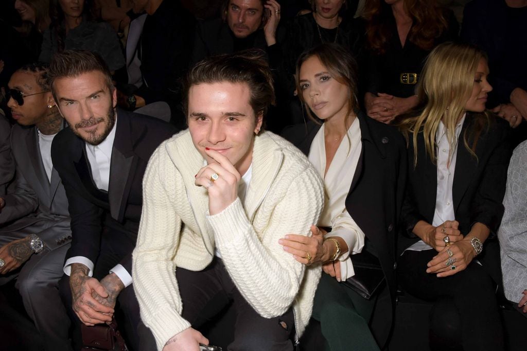 David Beckham, Brooklyn Beckham, Victoria Beckham  en el desfile de Dior en París, en 2021.