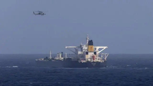 Un helicóptero vuela sobre un tanquero.