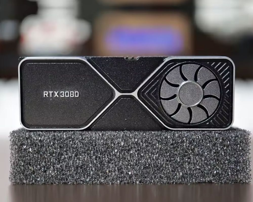 Primer plano de la keycap RTX 3080 mostrando la textura del metal y el ventilador giratorio.