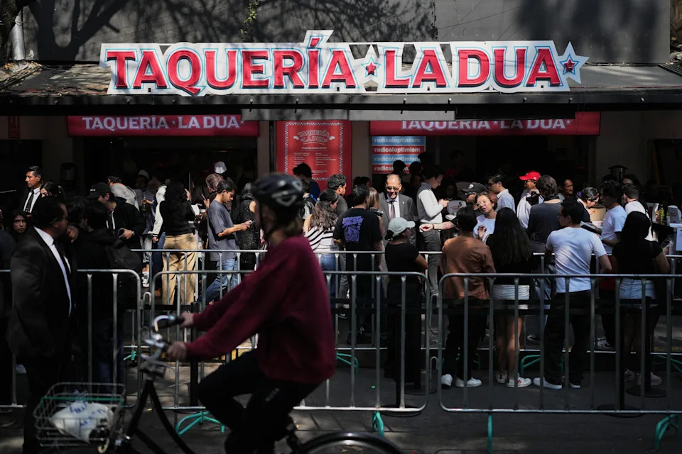 Fans y clientes formados durante la apertura la taquería La Dua de la estrella de la música, un restaurante emergente en la Ciudad de México, el lunes 1 de diciembre de 2025. (Foto AP/Eduardo Verdugo)