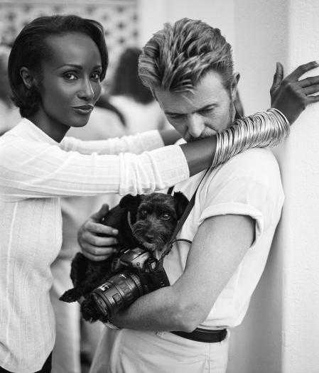 El cantante David Bowie besa el brazo de su mujer, la modelo Iman, acompañados de su perro y cámara, en Sudáfrica en 1995 