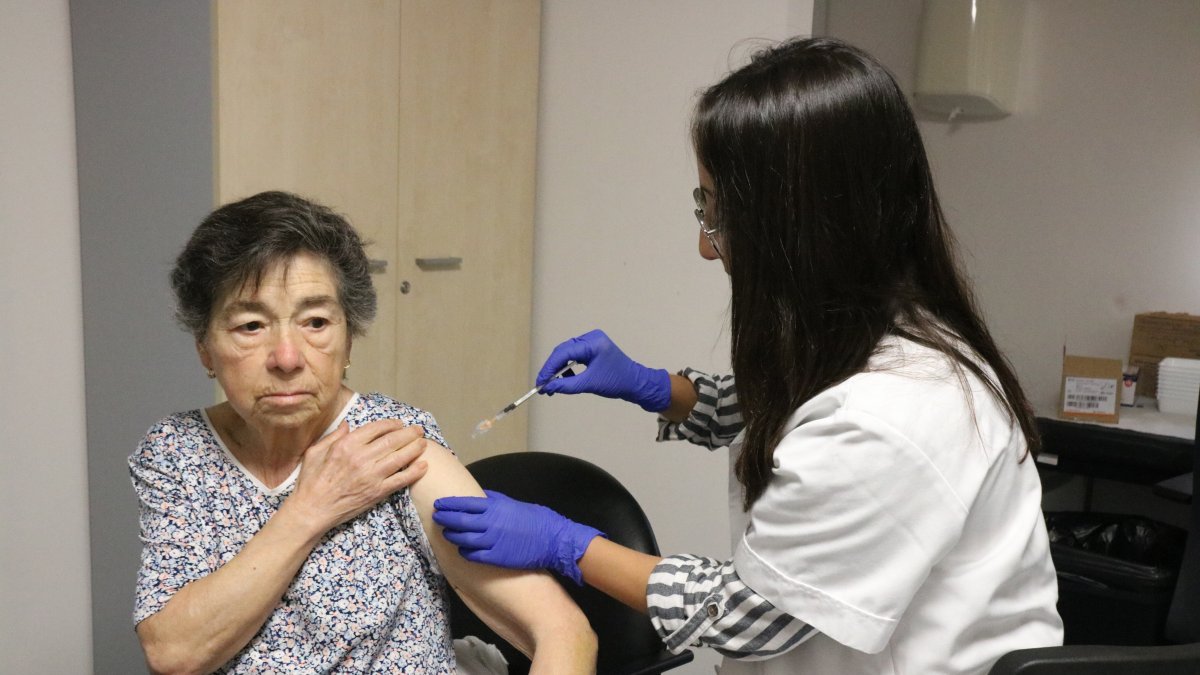 Un sanitario vacunando de la gripe y la covid.