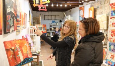 La pintora Marta Fàbregas (izquierda) en su taller de la calle Cardenal Vidal i Barraquer, atendiendo a un grupo.