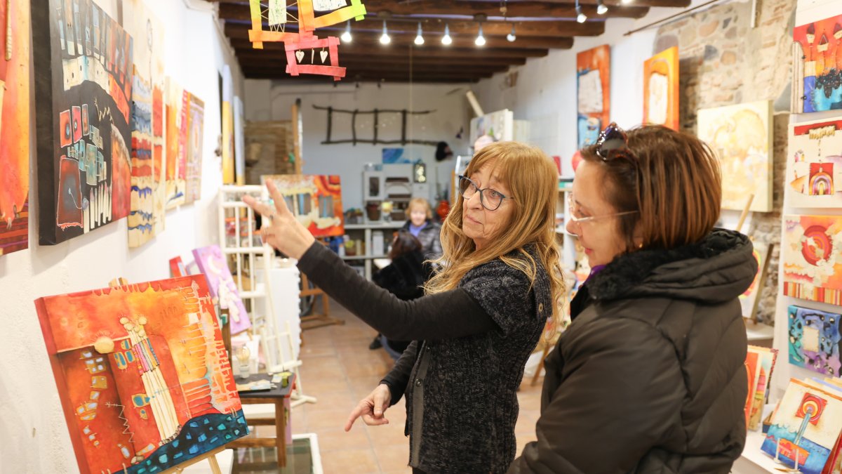 La pintora Marta Fàbregas (izquierda) en su taller de la calle Cardenal Vidal i Barraquer, atendiendo a un grupo.