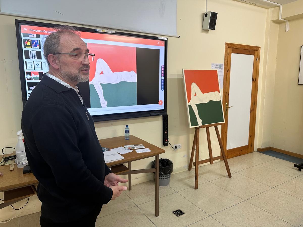 Gabino Busto durante su charla, dentro del ciclo "Mirar un cuadro", con la obra de José Santamina al fondo..