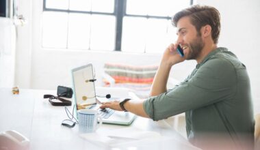 Chico de perfil sentado en una mesa y hablando por el móvil