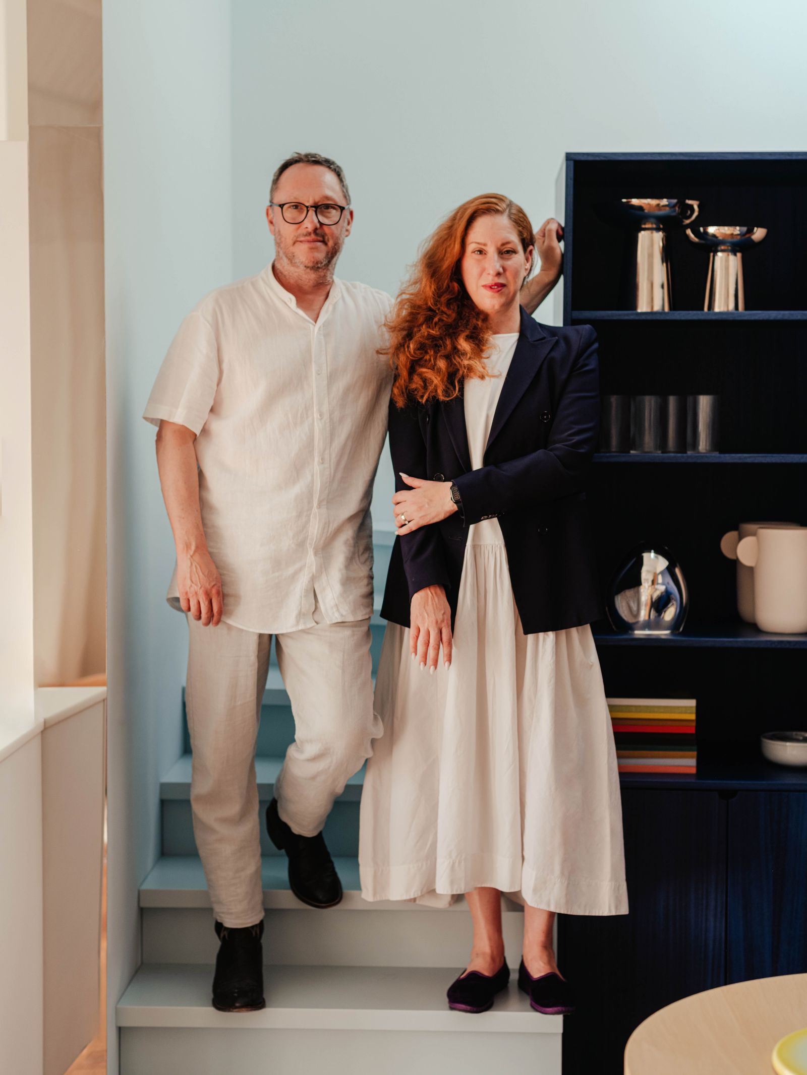 Un hombre y una mujer posan junto a un mueble azul