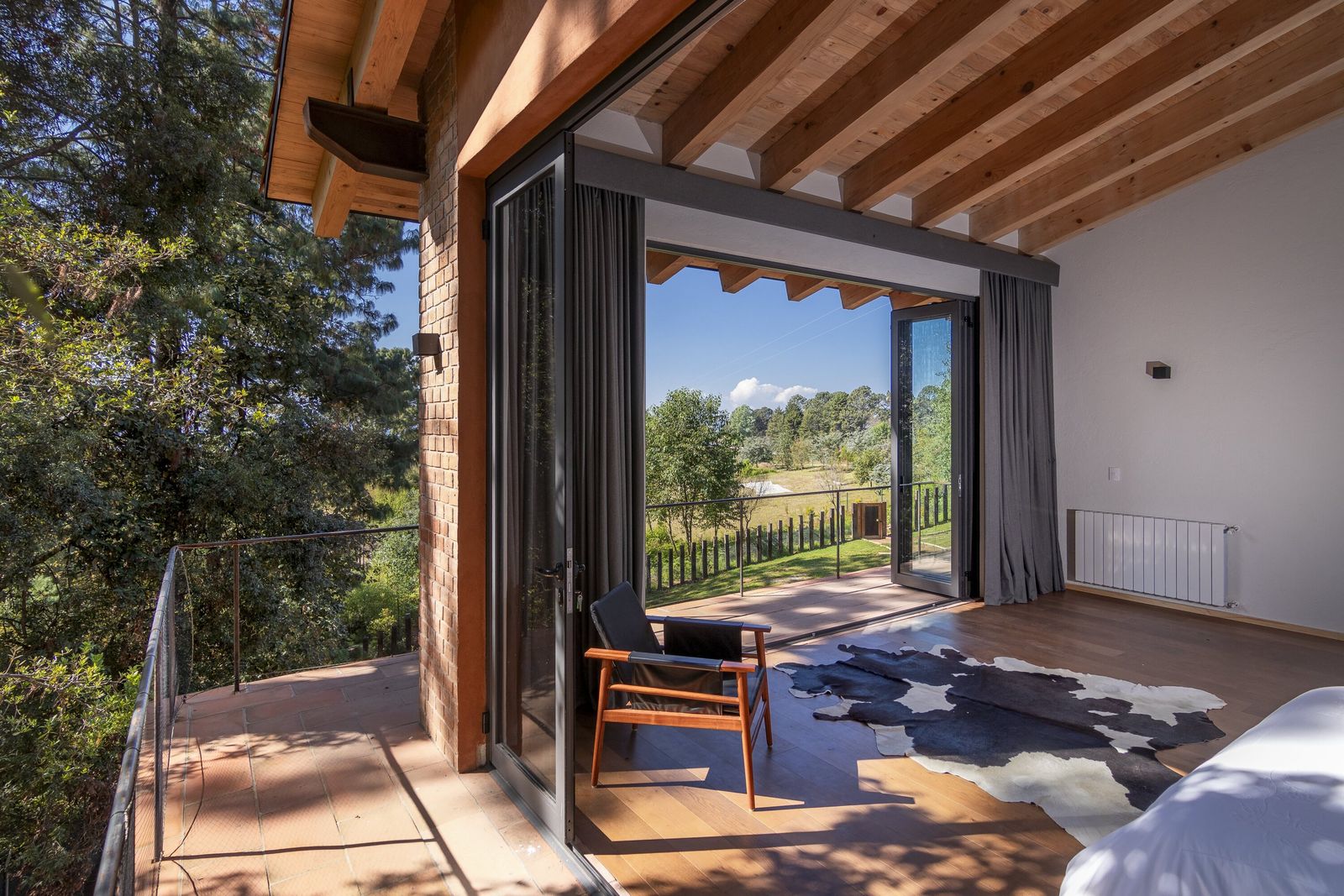 Habitación con vista a la naturaleza y tapete de vaca.