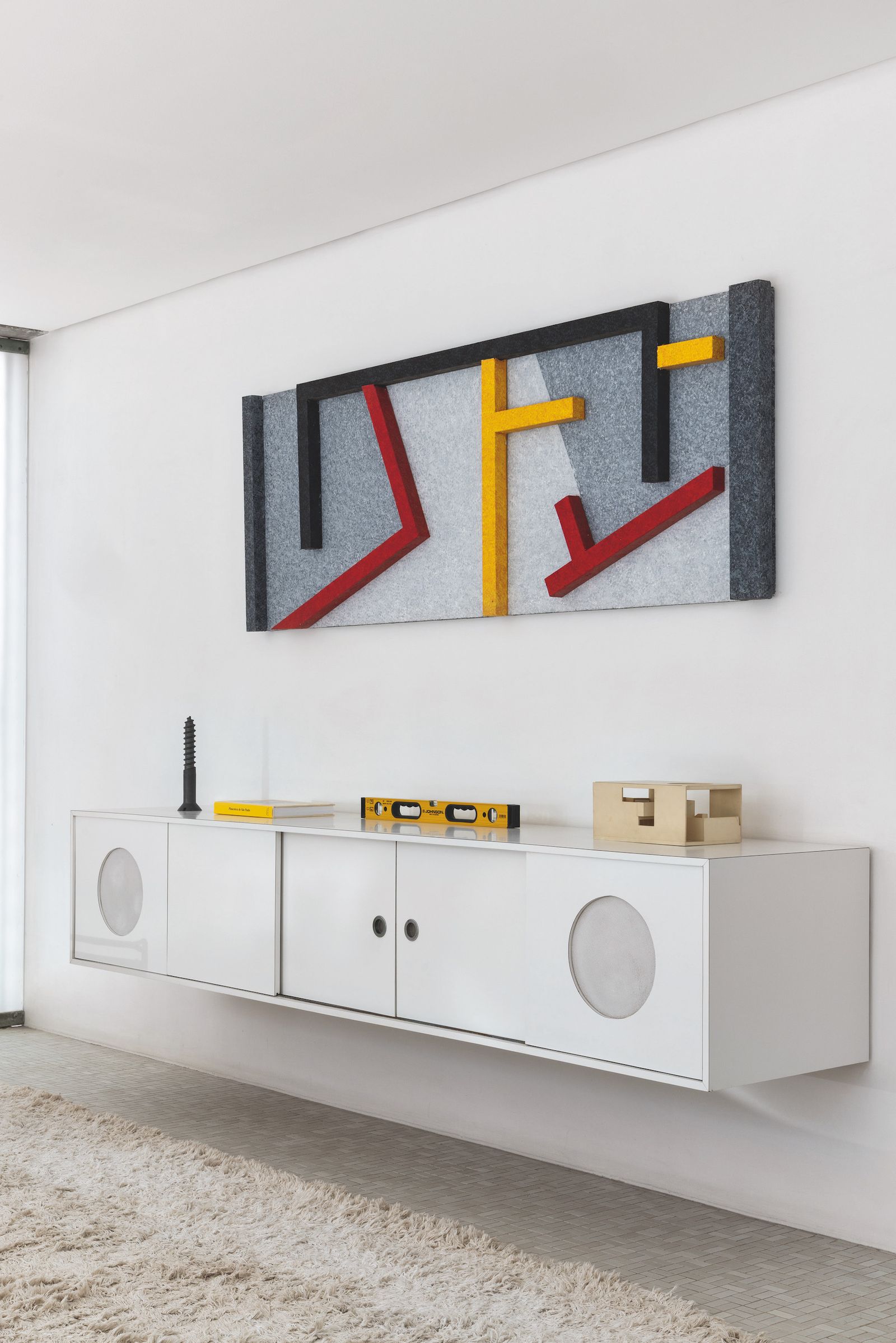 Estancia con cómoda suspendida y obra de arte colorida