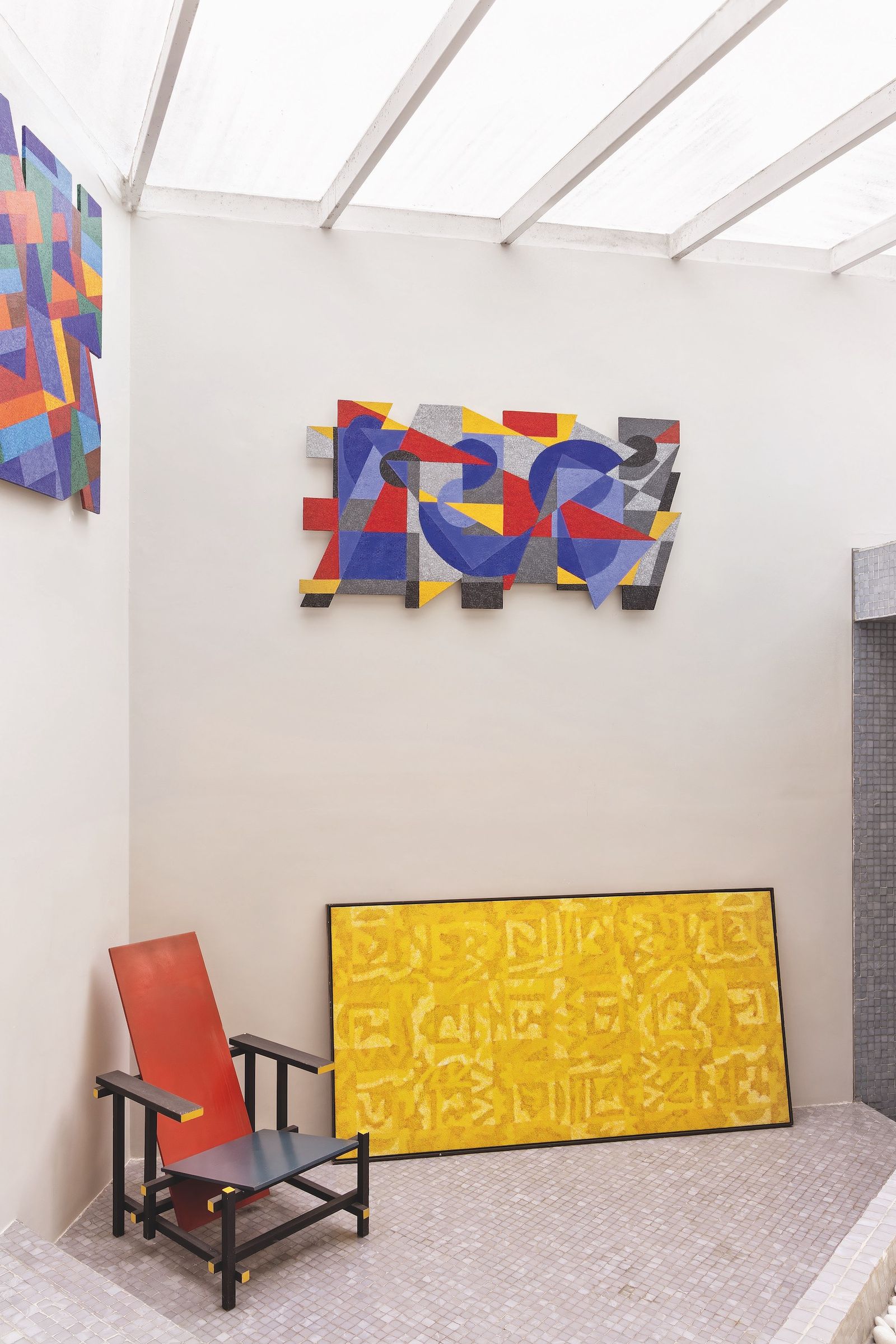 Estancia blanca con obras de arte coloridas y silla de Gerry Rietveld