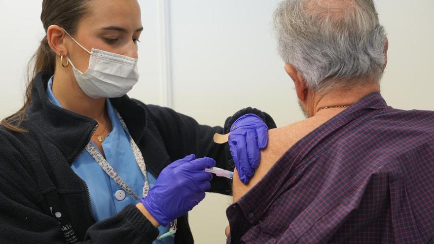 Una persona se vacuna, en un centro de refuerzo de vacunación frente a la gripe