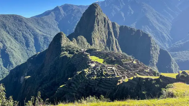 En la imagen se ve la antigua ciudad de Machu Picchu, rodeada por las verdes montañas de los Andes peruanos.