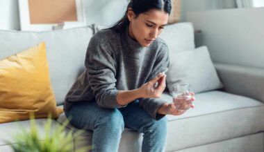 Mujer con una pastilla y un vaso de agua.