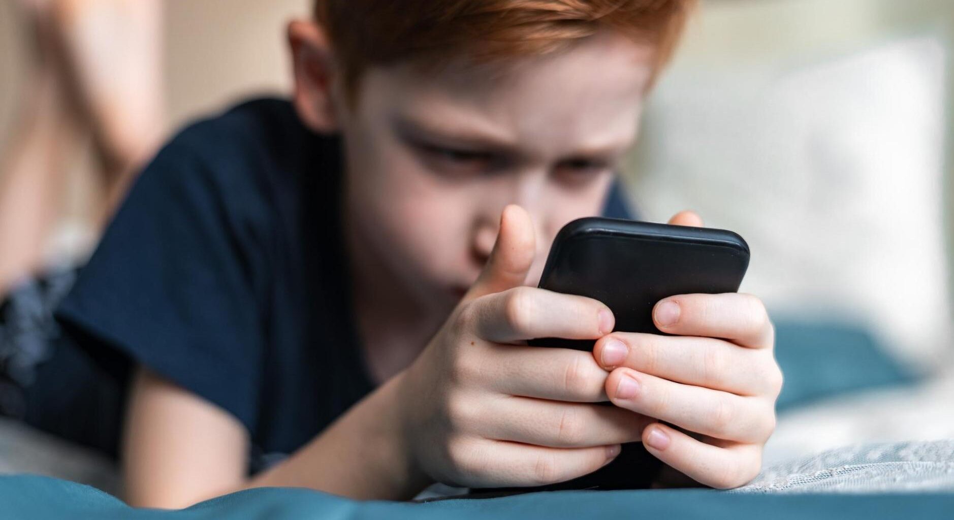 Niño mirando un teléfono móvil