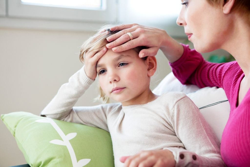 Niño con dolor de cabeza con su madre