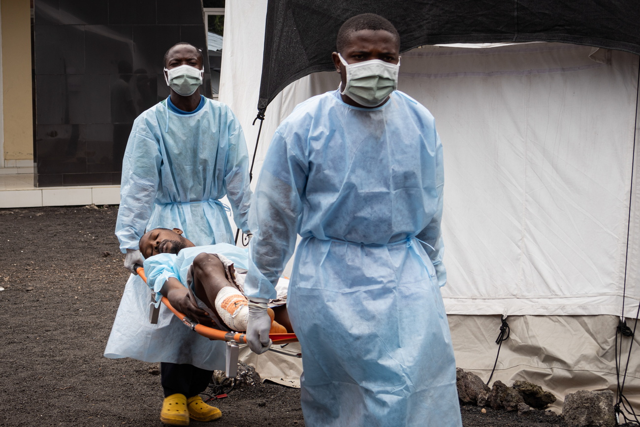 Dos hombres llevan a un hombre en una barra