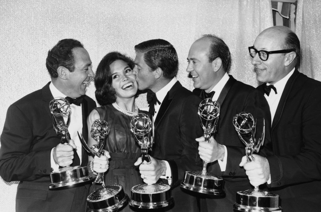 Van Dyke besa a Moore mientras sostienen sus premios Emmy en 1964.