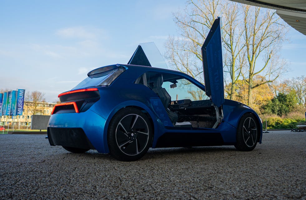 a futuristic blue car with butterfly doors open showcasing its interior