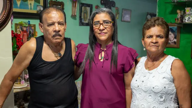 Ernesto Mendoza e Isidora Gómez con su hija Jovana abrazados mirando a la cámara.