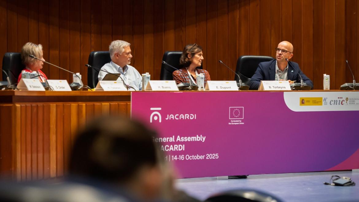Cuatro personas sentadas en una mesa principal en una reunión
