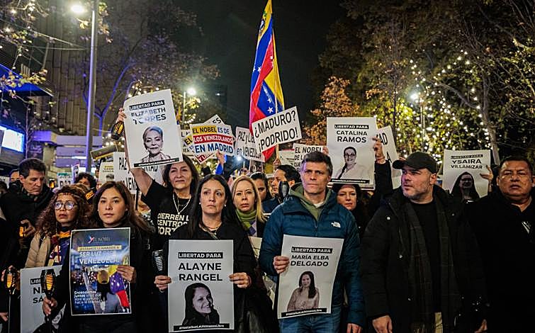 Imagen principal - El opositor Leopoldo López encabeza la marcha en Madrid, donde estuvo muy presente la imagen de María Corina Machado y abundaban los carteles contra el dictador chavista