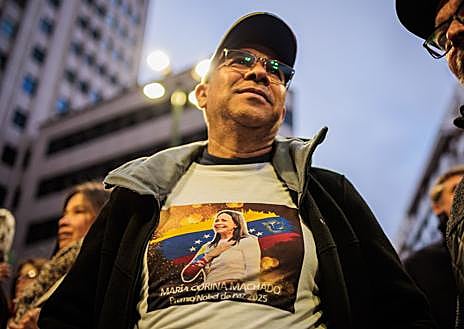 Imagen secundaria 1 - El opositor Leopoldo López encabeza la marcha en Madrid, donde estuvo muy presente la imagen de María Corina Machado y abundaban los carteles contra el dictador chavista
