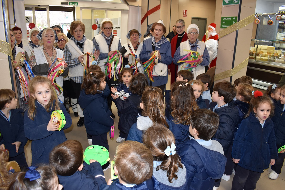 Los villancicos del Centro de Mayores «Margarita Salas» y del colegio María Inmaculada llenan de Navidad el Mercado Municipal