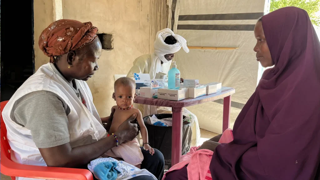 Una mujer sentada junto a su hijo en una consulta médica con una integrante de MSF en Sonori, Chad. 