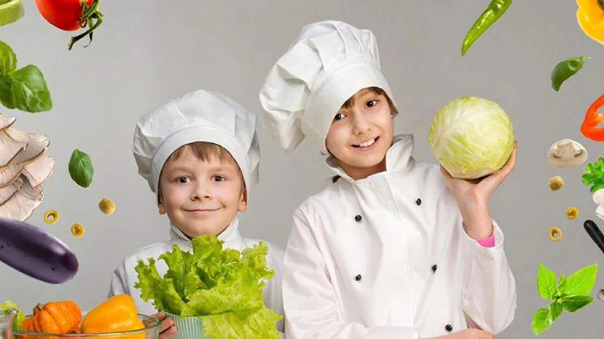 niños vestidos de cocineros con alimentos vegetales