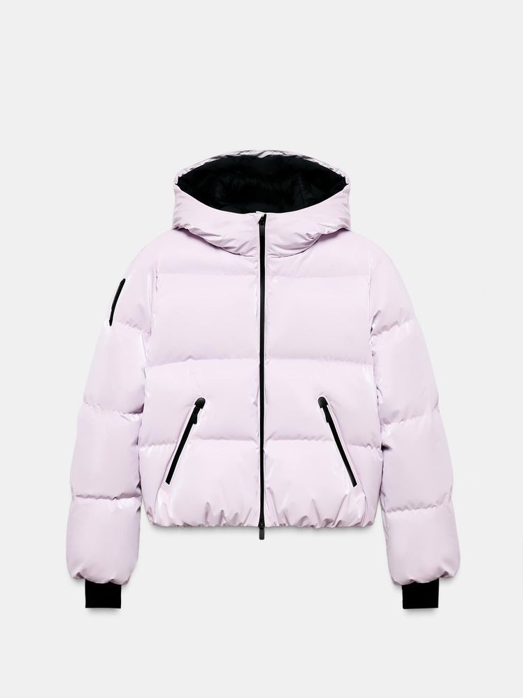 Plumífero resistente al agua color rosa claro. Tiene cuello subido con capucha ajustable, manga larga con bolsillo para el forfait acabada en elástico con puños con abertura para el pulgar. Tiene bajo acabado en elástico con cordones ajustables y faldón interior desmontable con cremallera y dobladillo ajustable para evitar la entrada de aire frío.