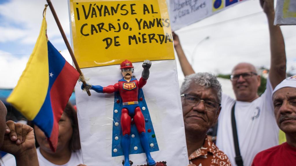 Un hombre sostiene un cartel con un muñeco de Super Bigote durante una manifestación este sábado, en Caracas (Venezuela).