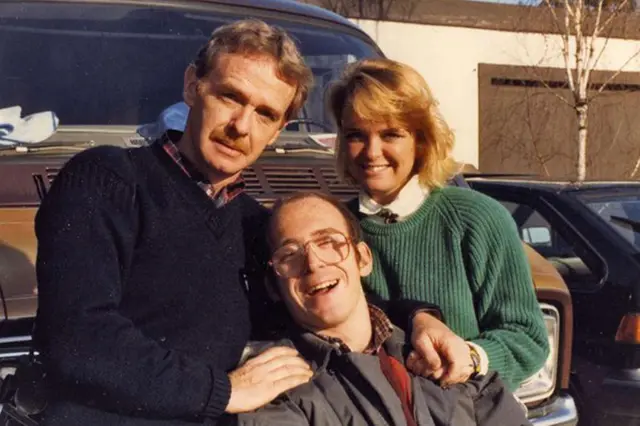 Chuck O'Rear, con un jersey azul marino, posa con su sonriente hija Stephanie Carpenter con un jersey verde y su hijo Michael, que tiene una discapacidad.