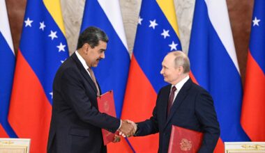 A la izquierda, Nicolás Maduro, expresidente de Venezuela, da la mano a Vladimir Putin, presidente de Rusia, en el Palacio del Kremlin, en Moscú (07/05/2025). Ambos portan una carpeta roja con el tratado de cooperación que acaban de firmar. Al fondo, varias banderas de Rusia y Venezuela.