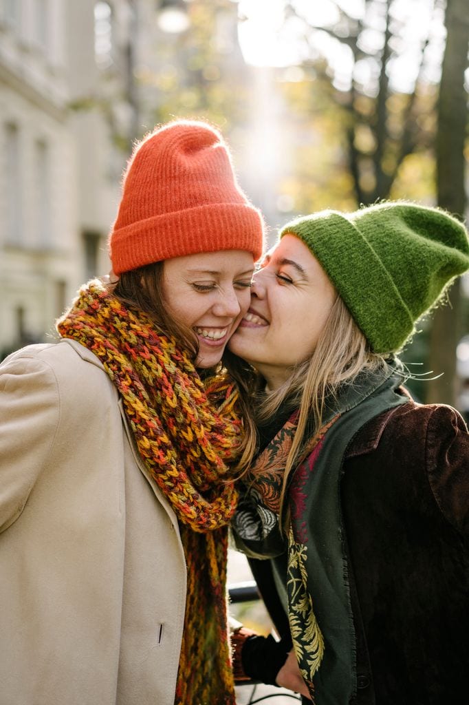 Amigas con gorros y bufandas divirtiéndose en invierno 