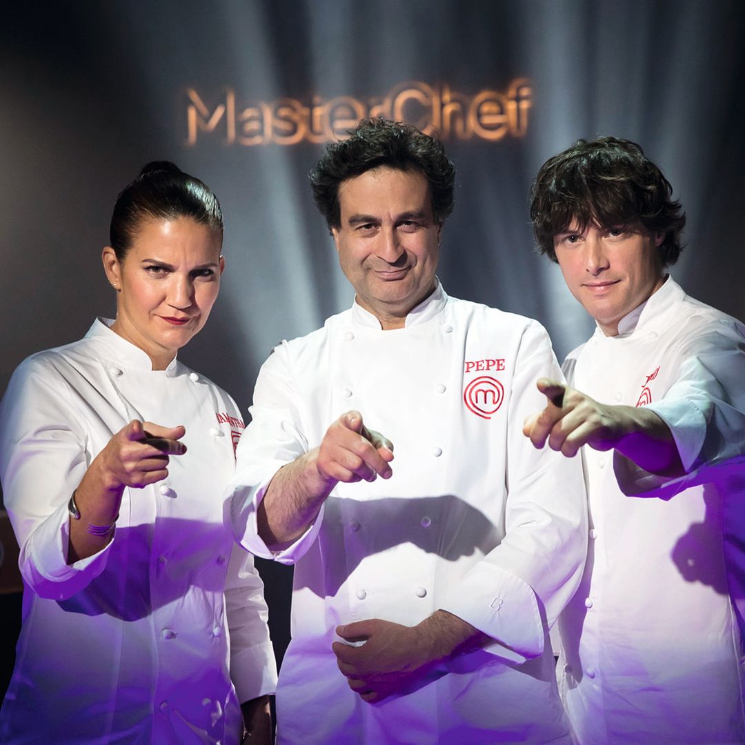 Samanta Vallejo-Nágera, Jordi Cruz y Pepe Rodríguez en uniformes de chef señalando, en un escenario de MasterChef.