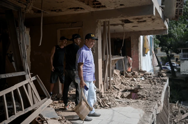 Unos hombres en una casa medio derruida por un misil de EE.UU.