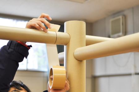 Construcción de divisiones simples, utilizando tubos de papel y cortinas de lona, para separar los espacios de cada familia evacuada tras un desastre natural o una guerra