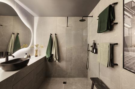 En el baño, el lujo se traduce en pureza de líneas: ducha a ras de suelo, encimera de dos metros con almacenaje invisible y un espejo retroiluminado