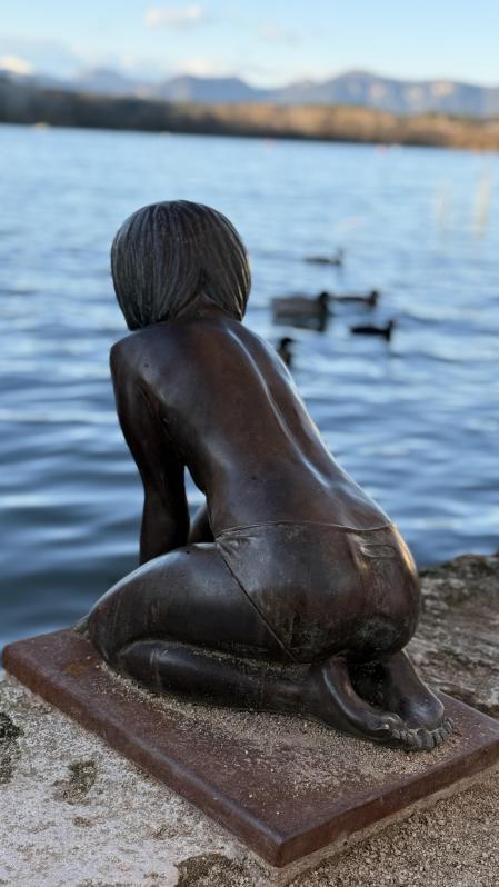 La bella escultura de la niña tocando el agua en el estanque de Banyoles.