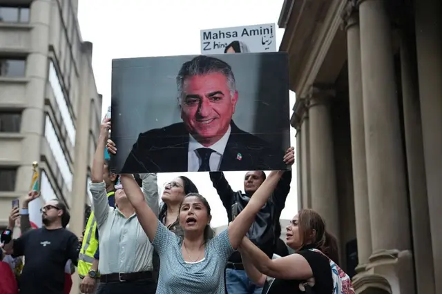 Una manifestante iraní promonárquica en Australia sostiene un retrato del heredero al trono.