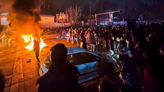 Un grupo de iraníes bloquea una calle de Teherán, la capital en la noche el viernes 9 de enero. Se ven barricadas de fuego.