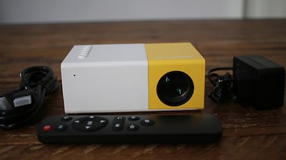 Proyector portátil en una mesa de madera.